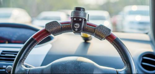 Close up of a car steering wheel with a lock on it
