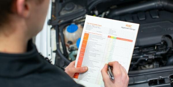 Mechanic looking at an RAC Warranty checklist