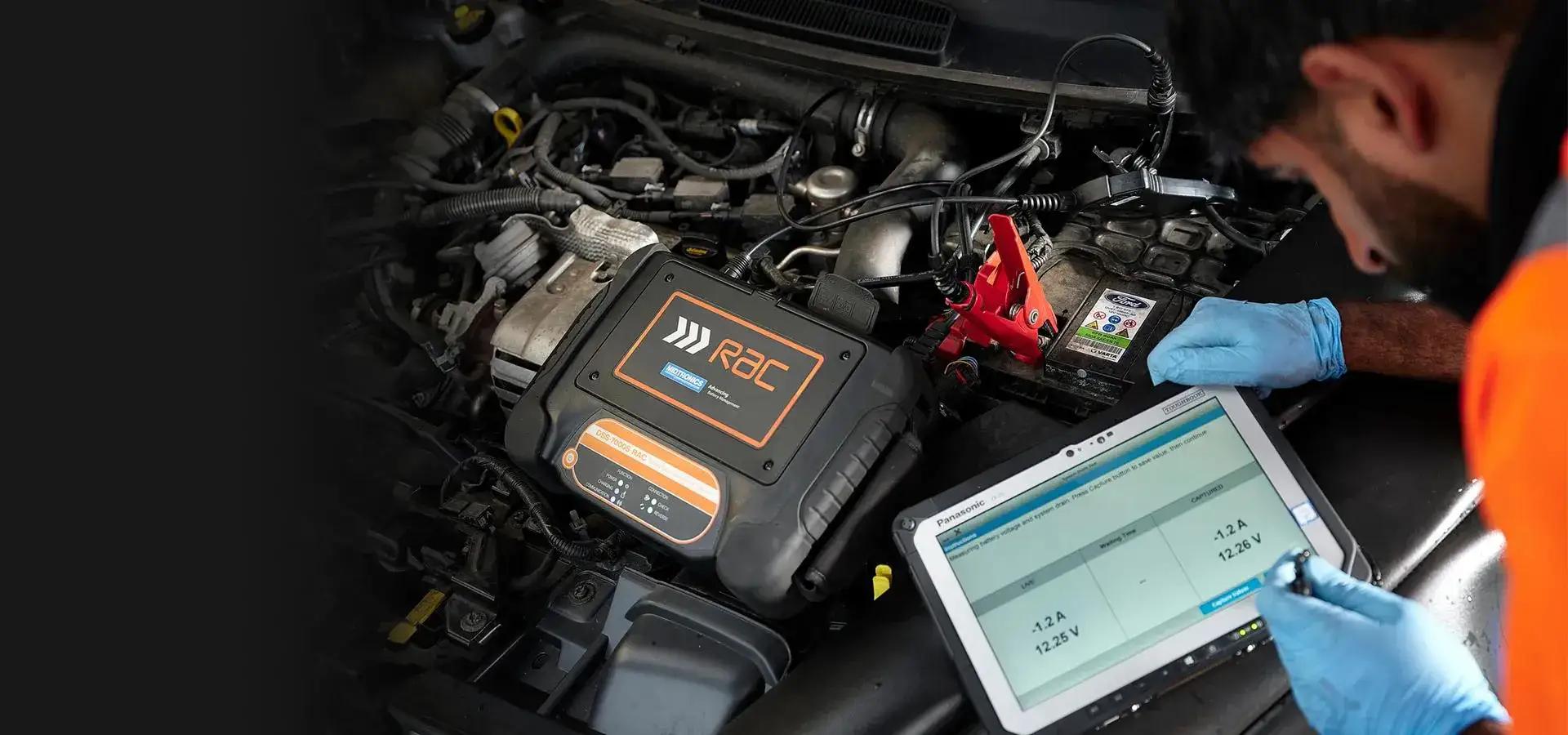 A mechanic using a diagnostic machine to inspect a car vehicle engine