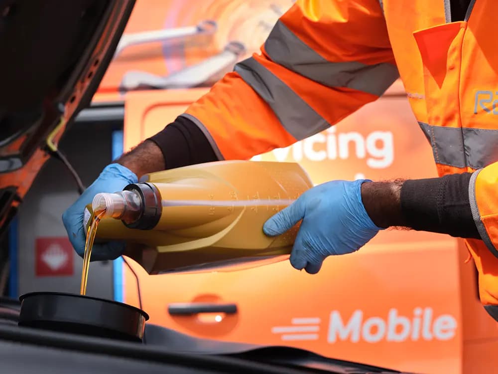 RAC Mobile Mechanic adding oil to a car